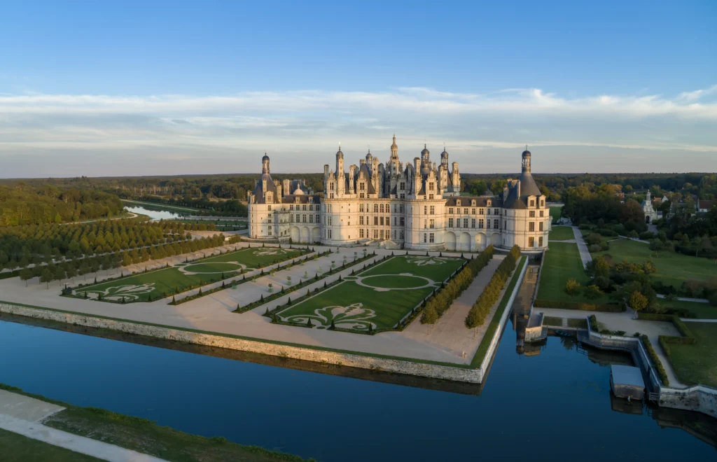 Vue aérienne du château de Chambord, de ses jardins à la française et de ses douves au cœur du domaine national.