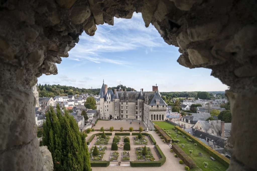 Château de Langeais et jardins vus à travers une ouverture dans les vestiges du donjon de Foulques Nerra.